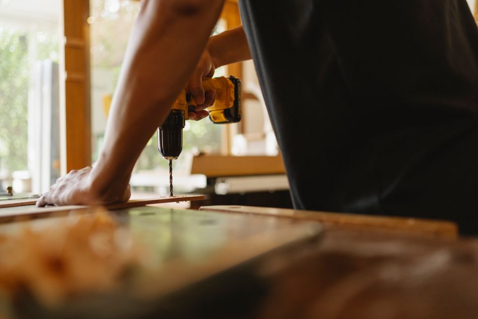 Carpenter carefully installing wooden custom kitchen cabinets